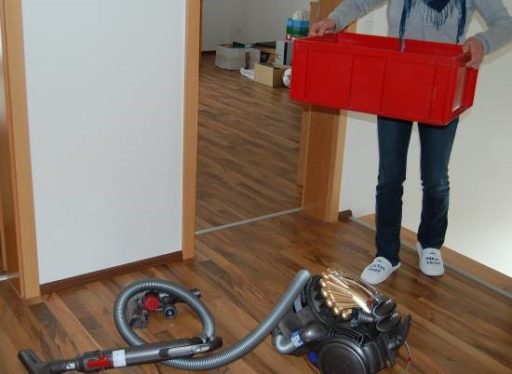 Auf dem Foto ist ein Staubsauger zu sehen, der mitten im Flur steht. 