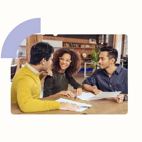 A woman sitting between two men and smiling.