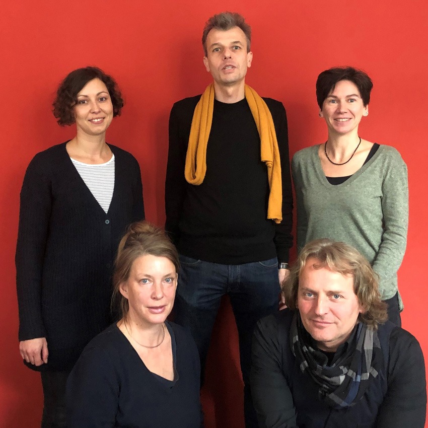 Foto von Andreas Wessel und dem capito Berlin Team. Drei Frauen und zwei Männer vor einem roten Hintergrund.