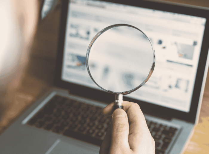 A photo of a laptop and a magnifying glass.