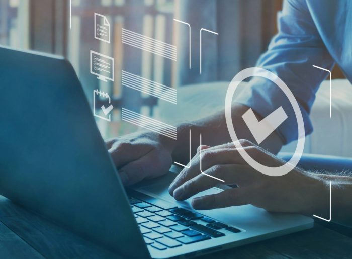 A photo of a person sitting in front of a laptop. A checkmark symbol can be seen above it.