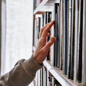 Hand greift zu leicht verständlichen Buch in einem Regal in der Stadtbibliothek Chur